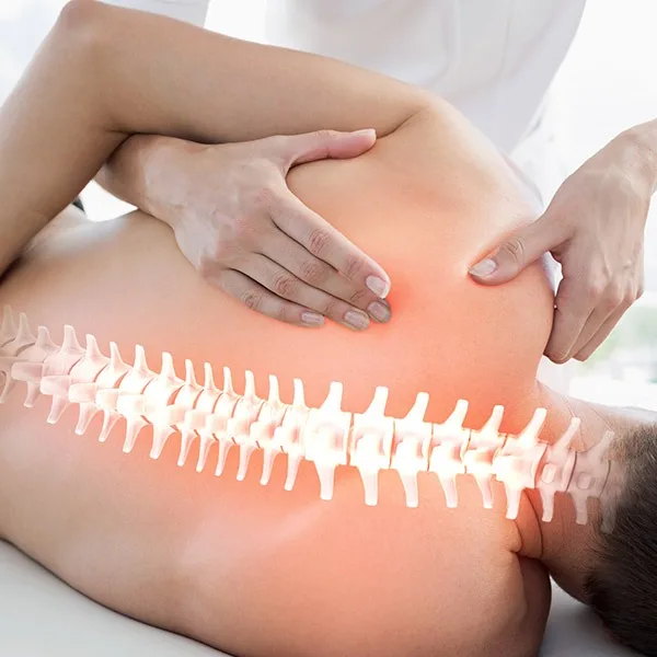 therapist massaging a persons lower back with a glowing red area plus a translucent spine diagram over the back to show anatomy